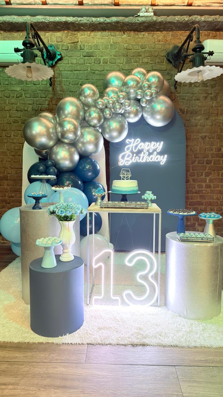 Aniversário de 13 anos no Vitral, com balões prata e azul e número 13 iluminado.