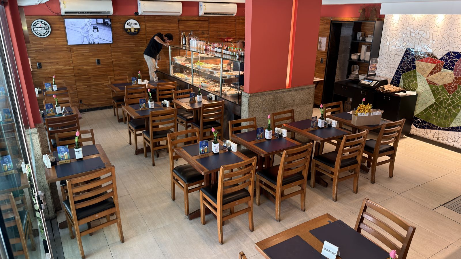 Buffet e salão do Vitral Bistrô, com o mosaico de vitral ao fundo.