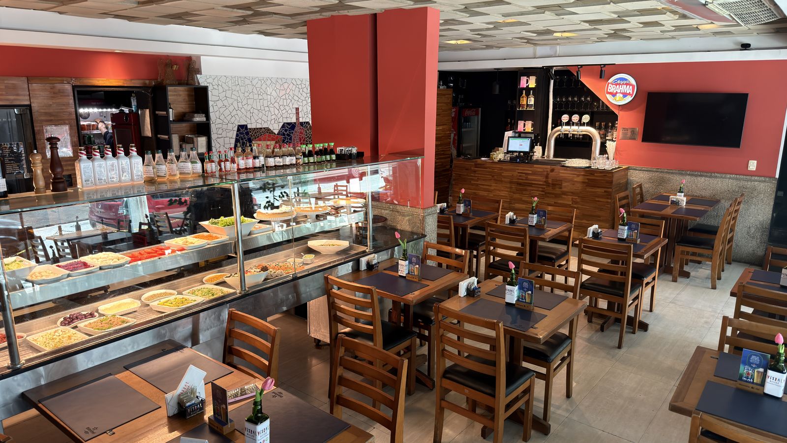 Salão do Vitral com buffet, torneiras de chopp e mesas de madeira.